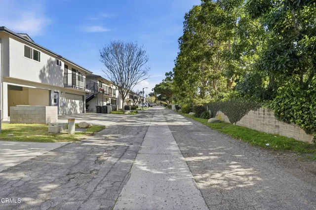 a view of residential houses with yard and green space