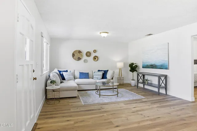a living room with furniture and wooden floor
