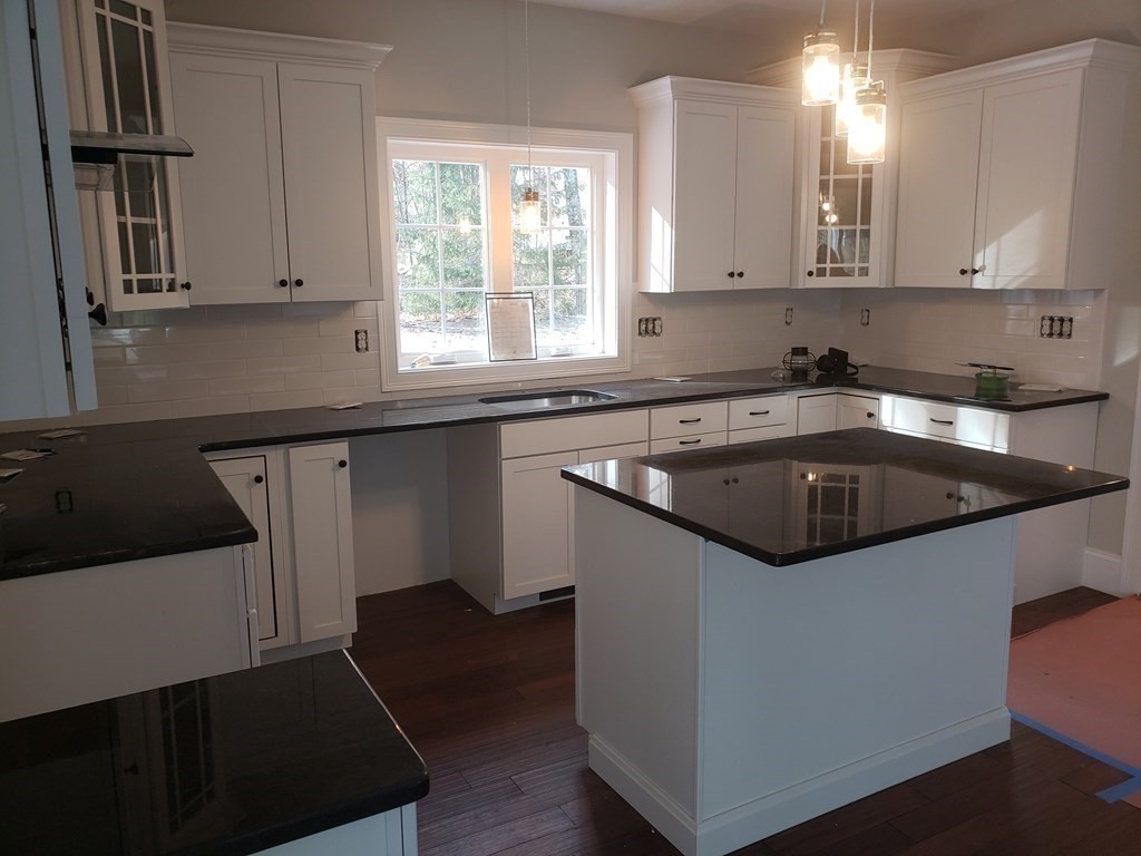 166 Pepperell Road Groton, MA 01450 - Photo 8 of 22 a kitchen with granite countertop a sink and a stove top oven with wooden floor