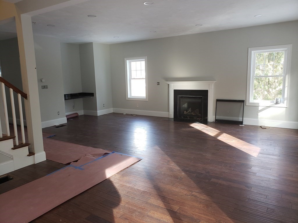 166 Pepperell Road Groton, MA 01450 - Photo 10 of 22 an empty room with wooden floor fireplace and windows