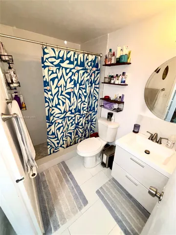 a bathroom with a sink toilet and shower curtain