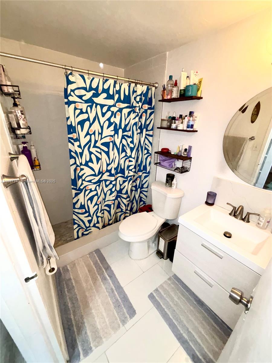 801 Brickell Bay Drive, Unit 1569 Miami, FL 33131 - Photo 12 of 19 a bathroom with a sink toilet and shower curtain