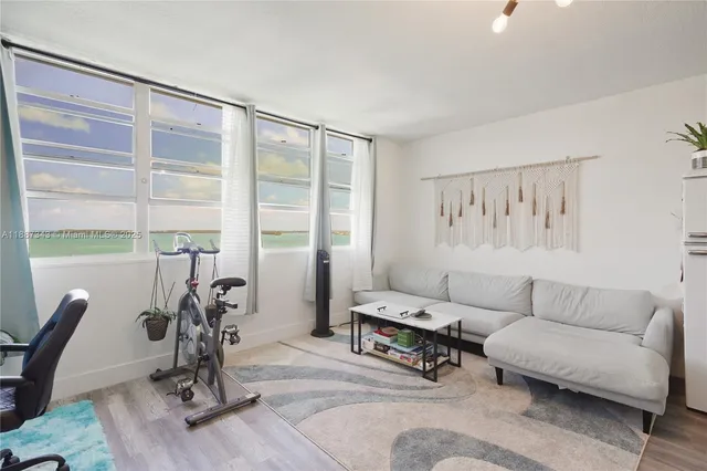 a living room with furniture a dining table and a large window