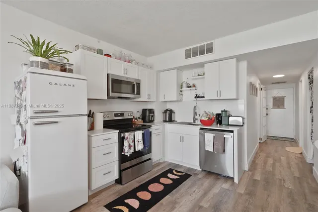a kitchen with white cabinets and white appliances