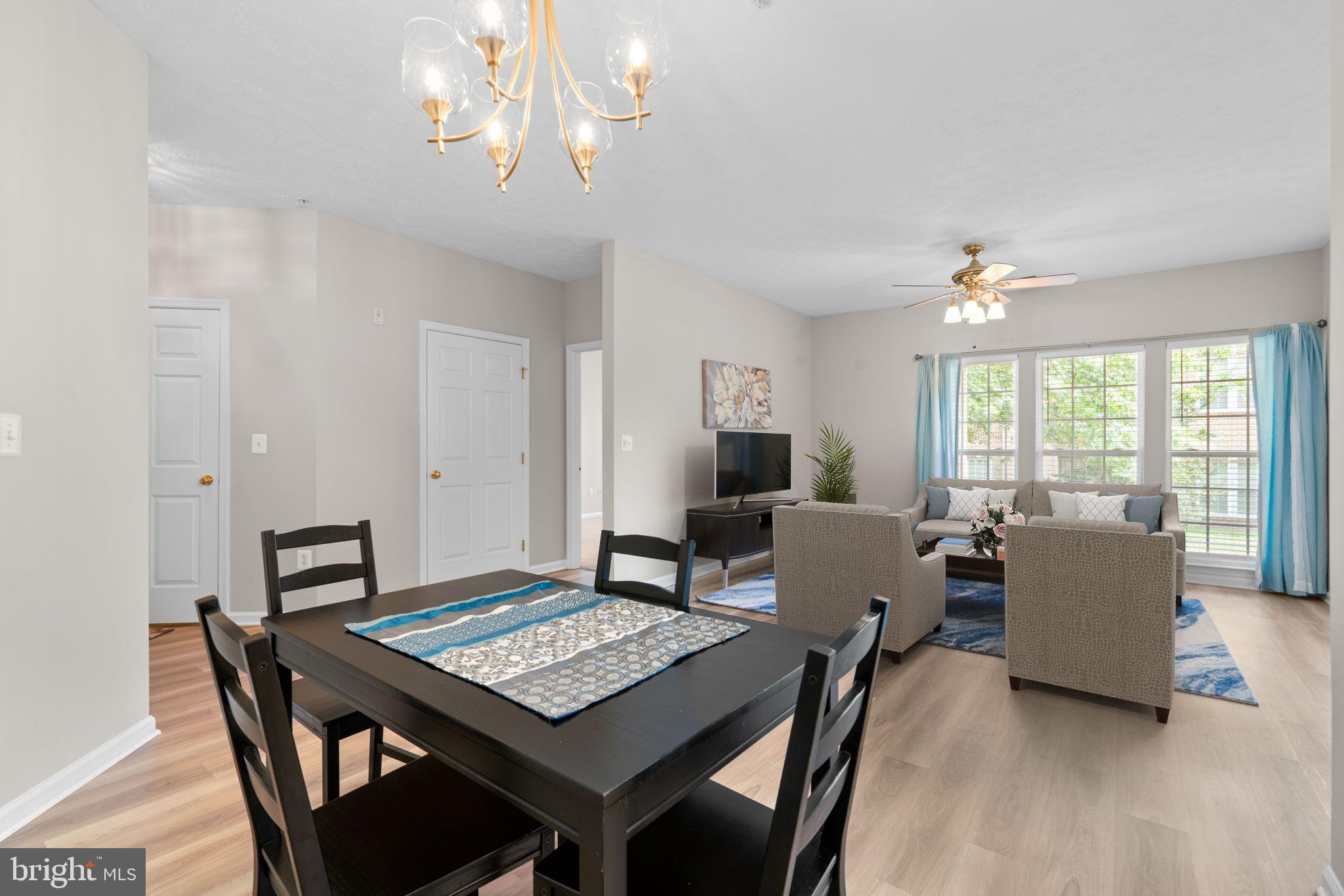 5215 Glenthorne Court, Unit 5215 Rosedale, MD 21237 - Photo 9 of 22 a view of a dining room with furniture a chandelier and wooden floor