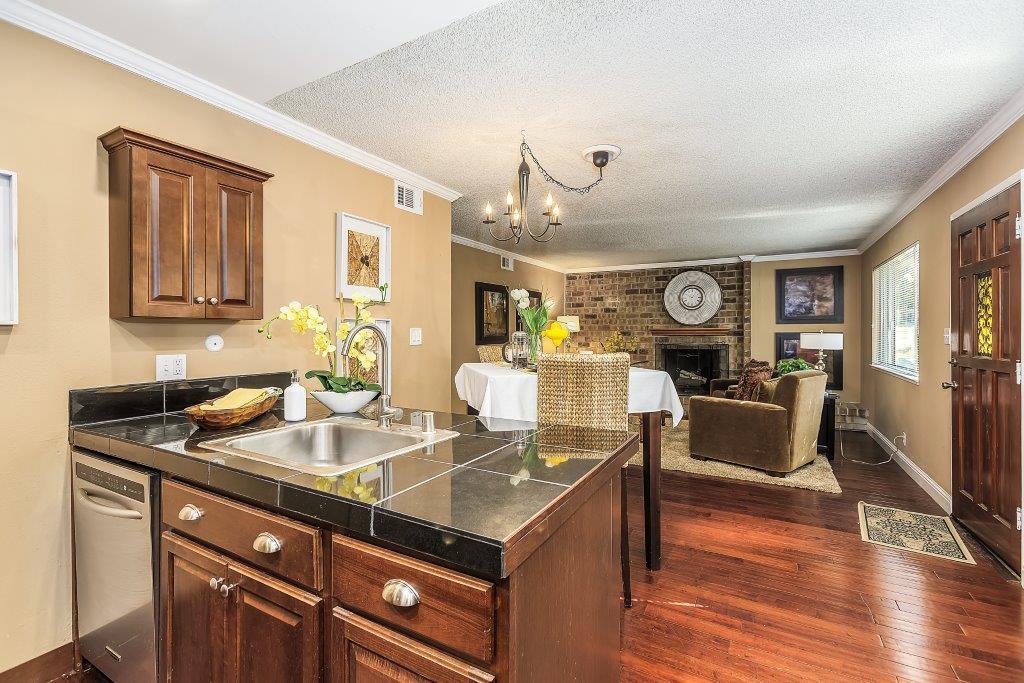 2329 Foothill Road, Unit 1 Pleasanton, CA 94588 - Photo 7 of 15 a kitchen with a stove a sink dishwasher and a dining table with wooden floor