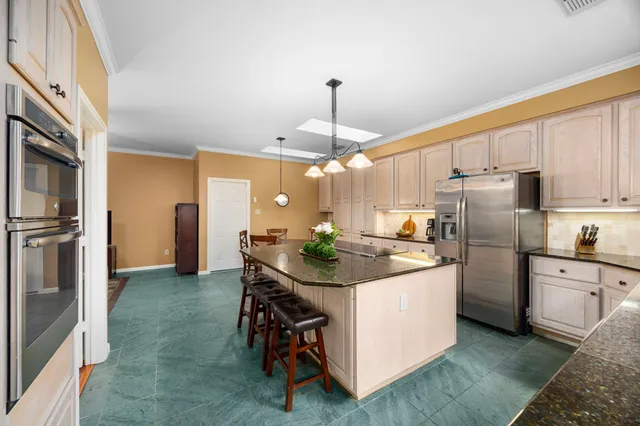 a kitchen with stainless steel appliances granite countertop a sink stove and refrigerator