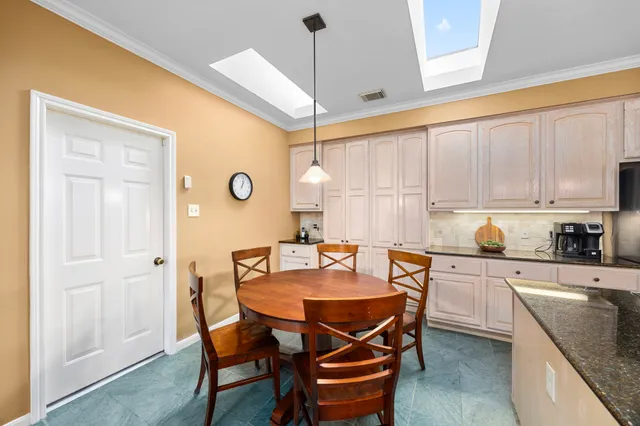 a kitchen with a table chairs and a refrigerator