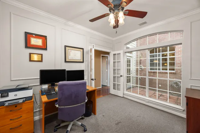 a view of a workspace with furniture and a window