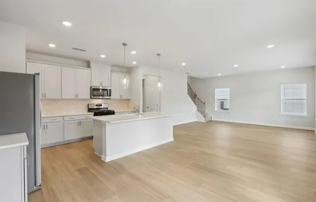 a kitchen with white cabinets and stainless steel appliances