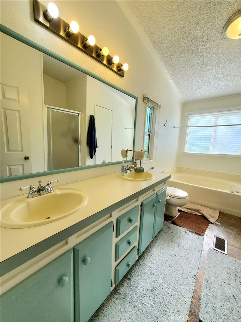 29021 Bouquet Canyon Road, Unit 213 Saugus, CA 91350 - Photo 17 of 17 a bathroom with a double vanity sink mirror and toilet