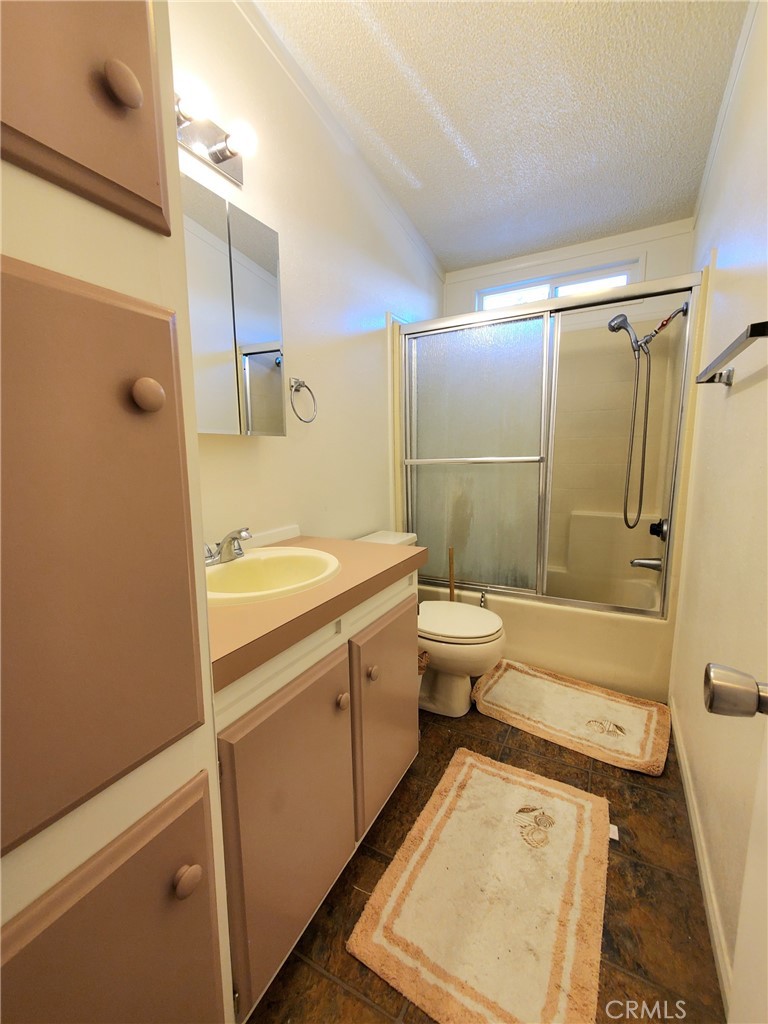 29021 Bouquet Canyon Road, Unit 213 Saugus, CA 91350 - Photo 10 of 17 a bathroom with a sink a toilet and shower