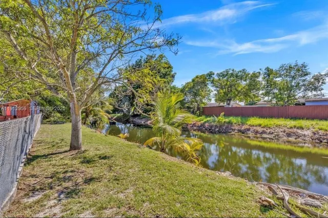 a view of backyard with wooden fence