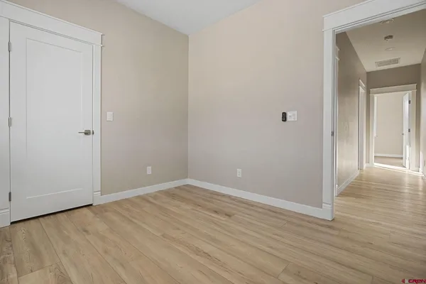 a view of an empty room with wooden floor