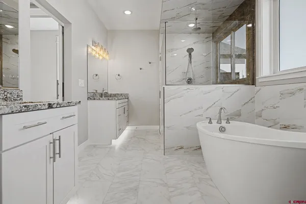 a bathroom with a bathtub sink and mirror