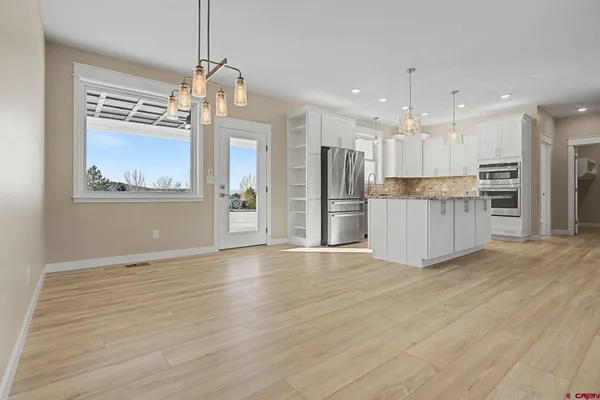 a view of a kitchen with a refrigerator wooden floor and a ceiling fan