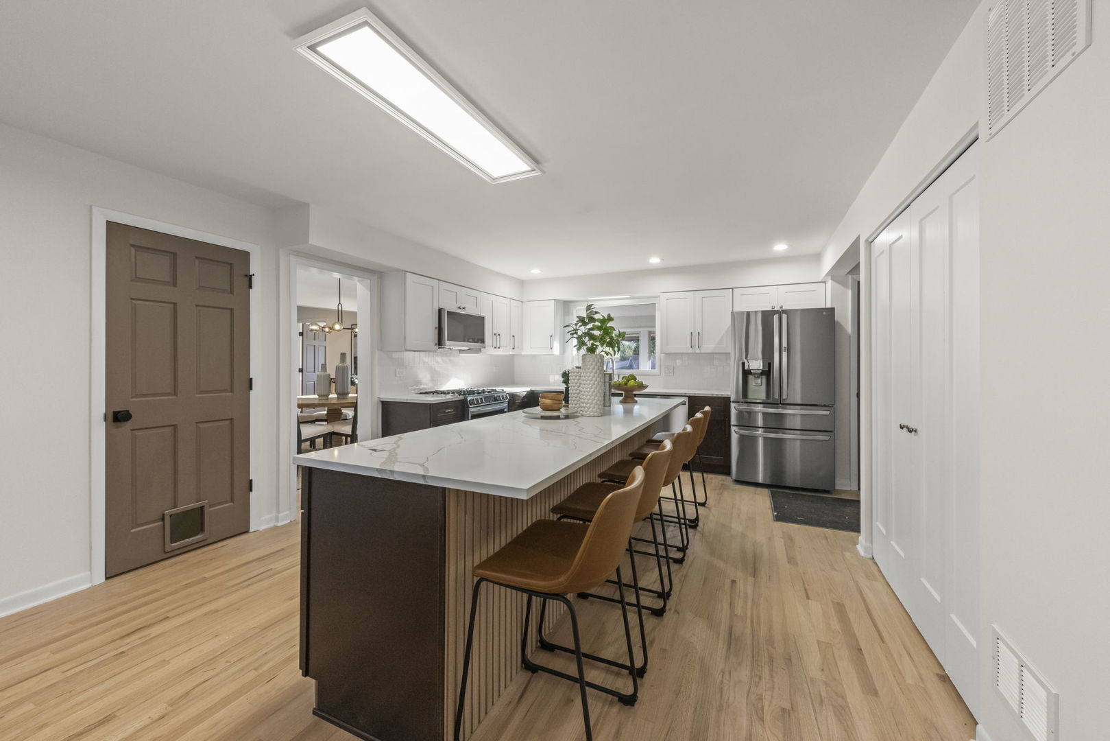 2823 Cooper Court Woodridge, IL 60517 - Photo 18 of 32 a kitchen with stainless steel appliances kitchen island granite countertop a refrigerator a stove a sink dishwasher and white cabinets with wooden floor