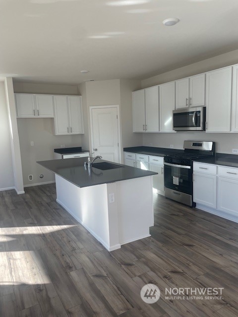 2822 Laurel Loop Milton, WA 98354 - Photo 2 of 6 a large kitchen with stainless steel appliances granite countertop a stove a sink and white cabinets