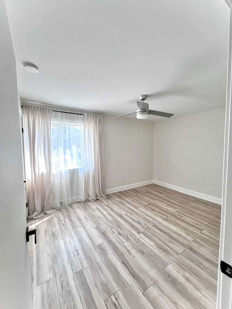 244 East Rimini Court Palatine, IL 60067 - Photo 5 of 8 wooden floor in an empty room with a window