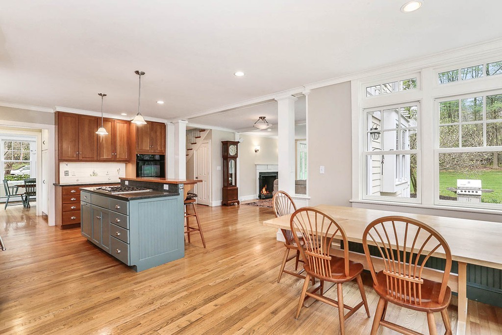 10 Woodside Road Topsfield, MA 01983 - Photo 3 of 30 a kitchen with stainless steel appliances kitchen island granite countertop a stove a refrigerator a sink a dining table and chairs with wooden floor