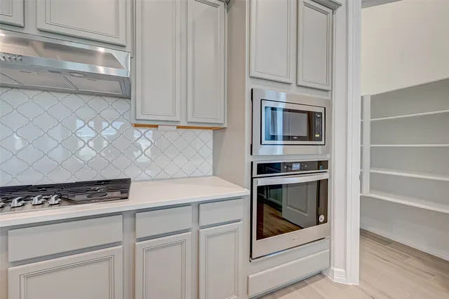 a kitchen with white cabinets and appliances