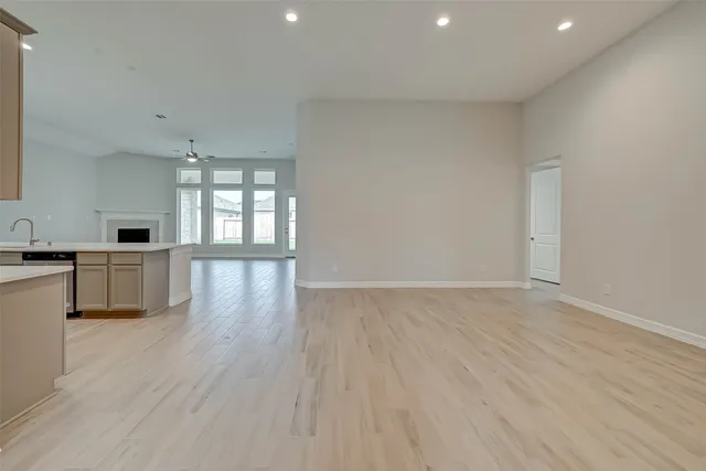a view of empty room with wooden floor and window