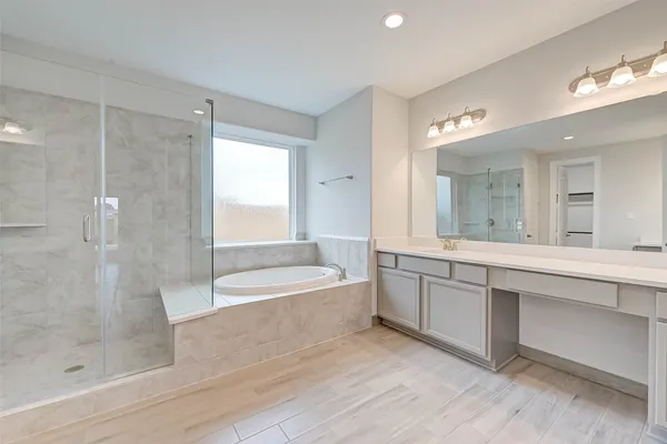 a bathroom with a bathtub shower sink and mirror