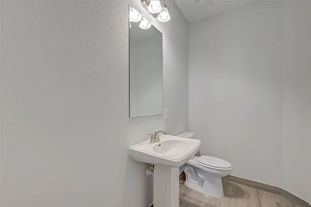 a bathroom with a sink a toilet and a mirror