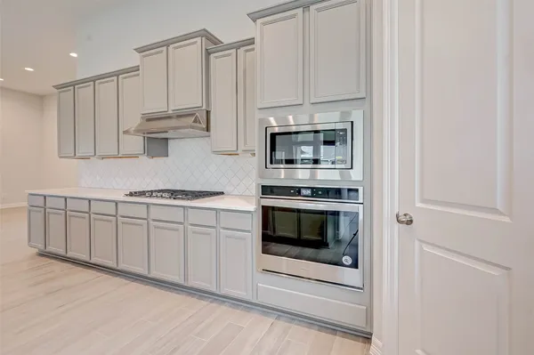 a kitchen with stainless steel appliances granite countertop a stove a sink and a microwave