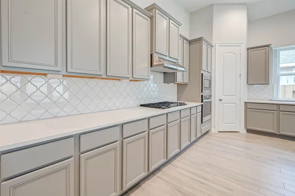 a kitchen with white cabinets and sink