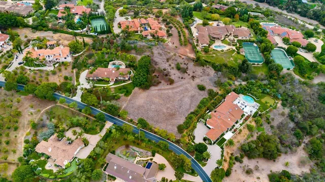 an aerial view of residential houses with outdoor space and trees