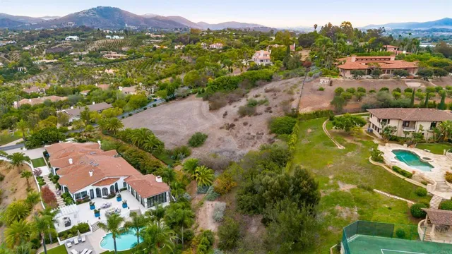 an aerial view of residential houses with outdoor space and trees