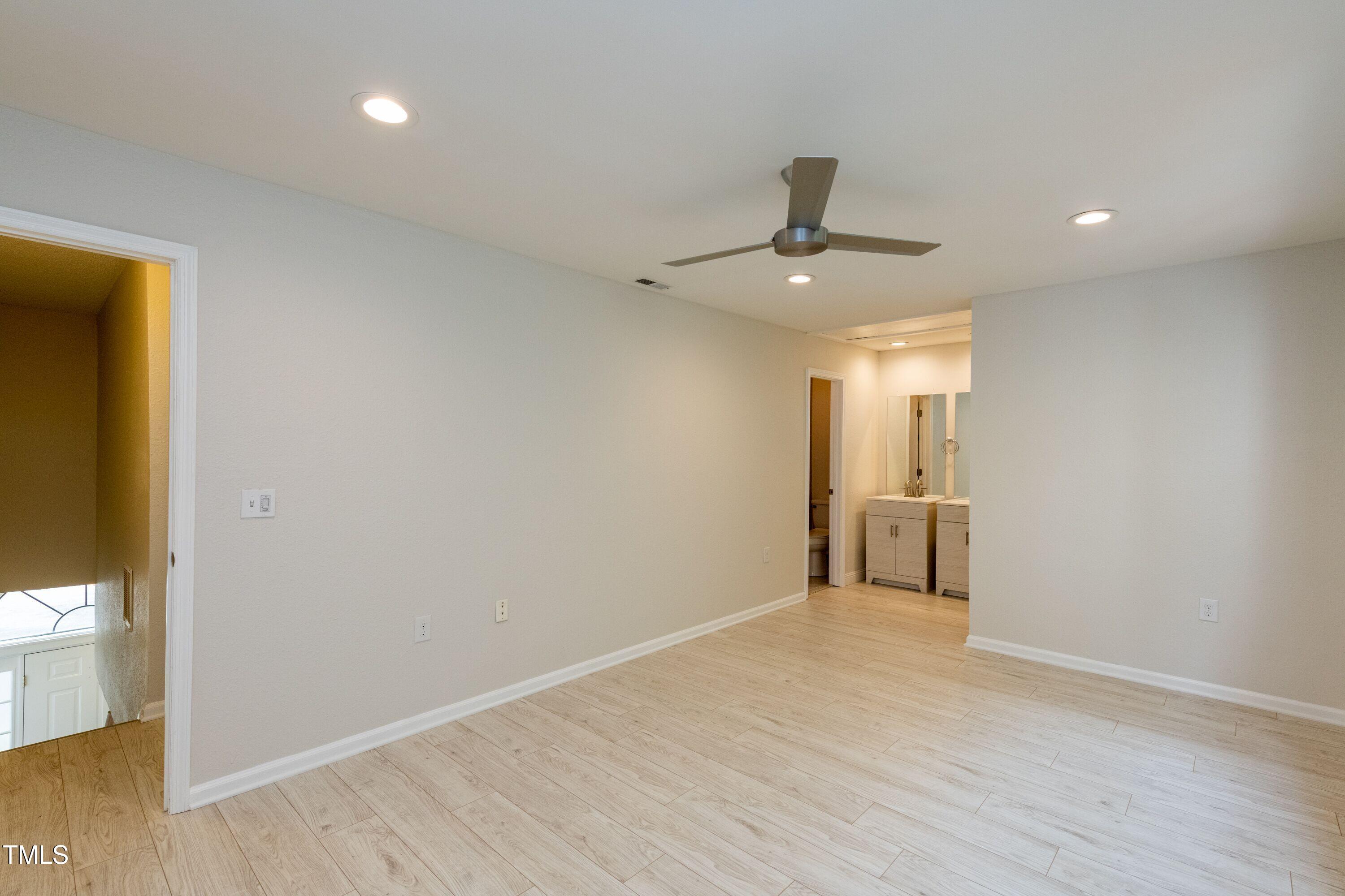 2434 Condor Court Raleigh, NC 27615 - Photo 13 of 21 a view of a hallway with wooden floor and a bathroom