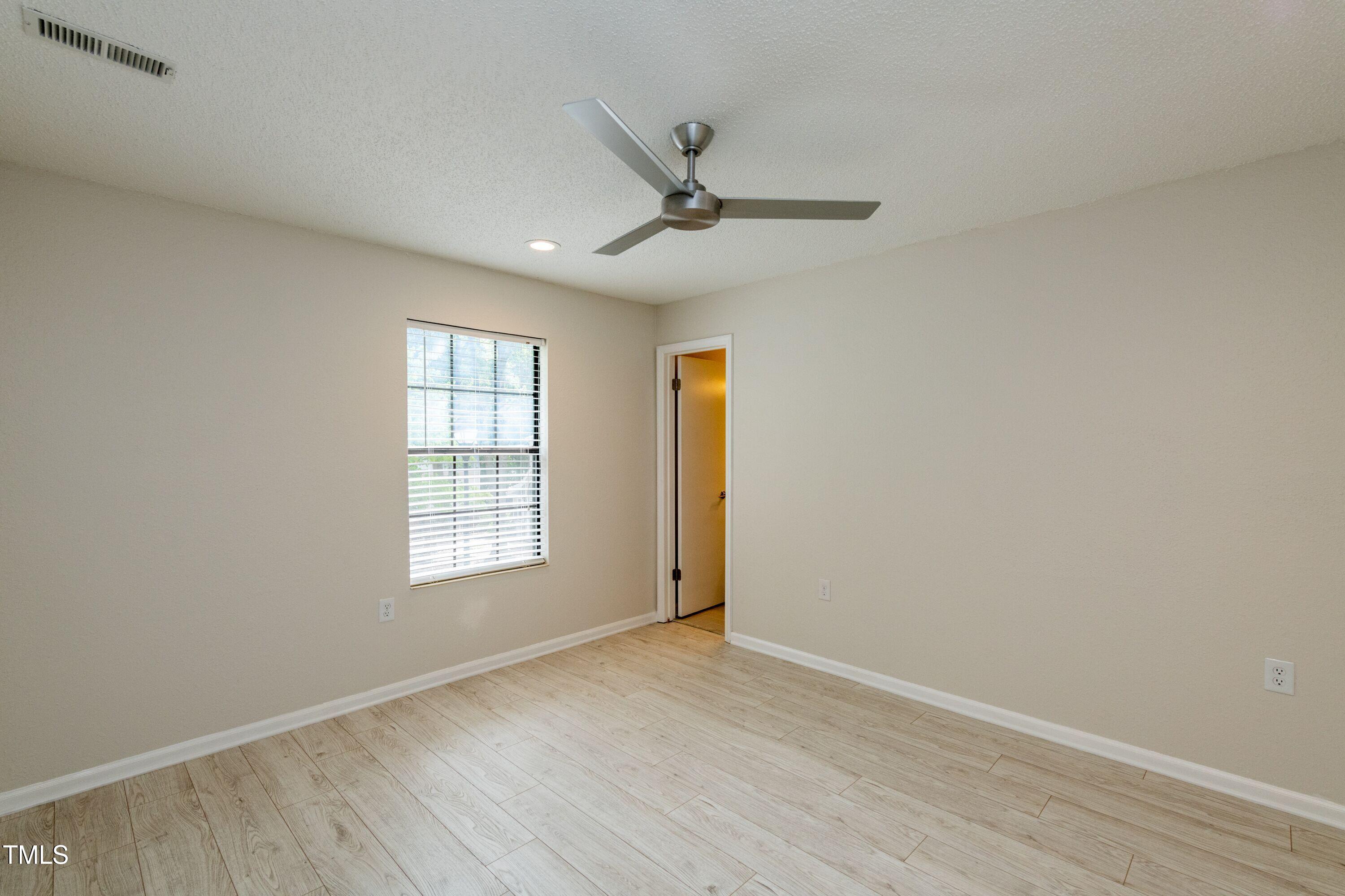 2434 Condor Court Raleigh, NC 27615 - Photo 16 of 21 wooden floor in an empty room with a window