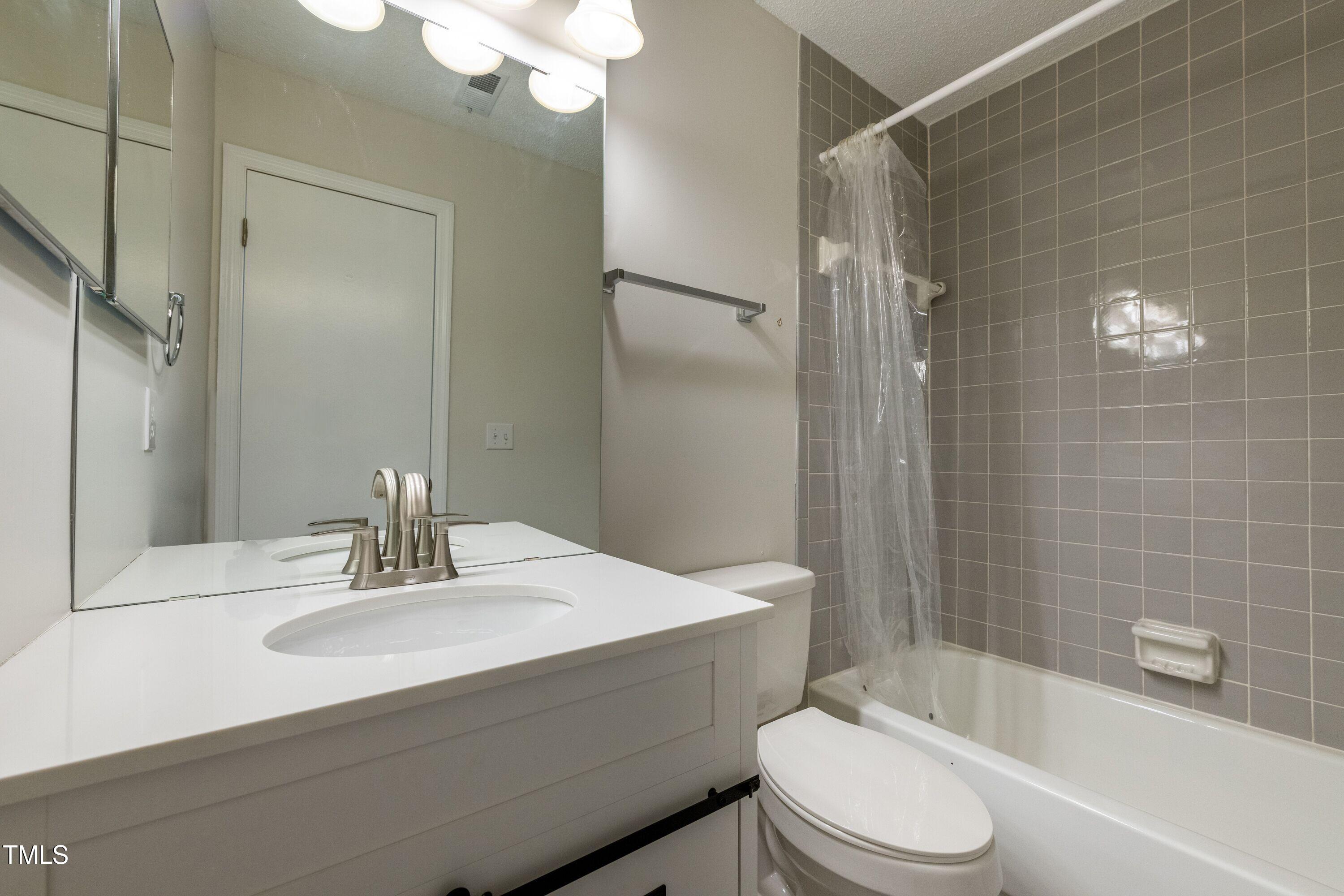 2434 Condor Court Raleigh, NC 27615 - Photo 17 of 21 a bathroom with a sink a toilet and shower