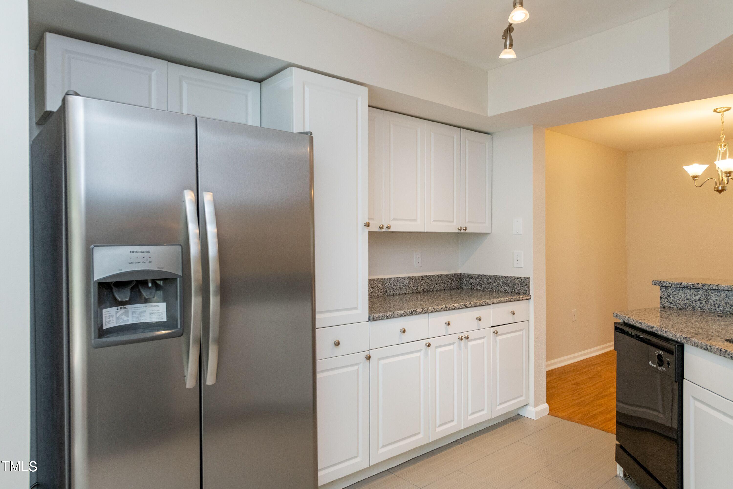 2434 Condor Court Raleigh, NC 27615 - Photo 6 of 21 a kitchen with granite countertop a refrigerator and a sink