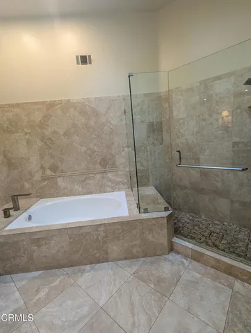 a spacious bathroom with a bathtub and a shower