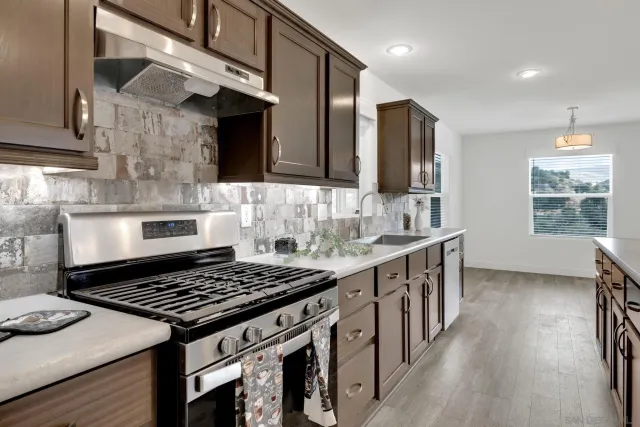 a kitchen with kitchen island granite countertop wooden cabinets and white appliances