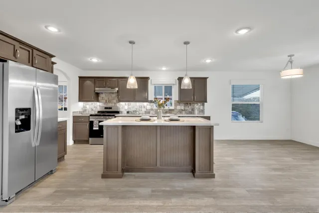 a view of kitchen with kitchen island stainless steel appliances sink and microwave