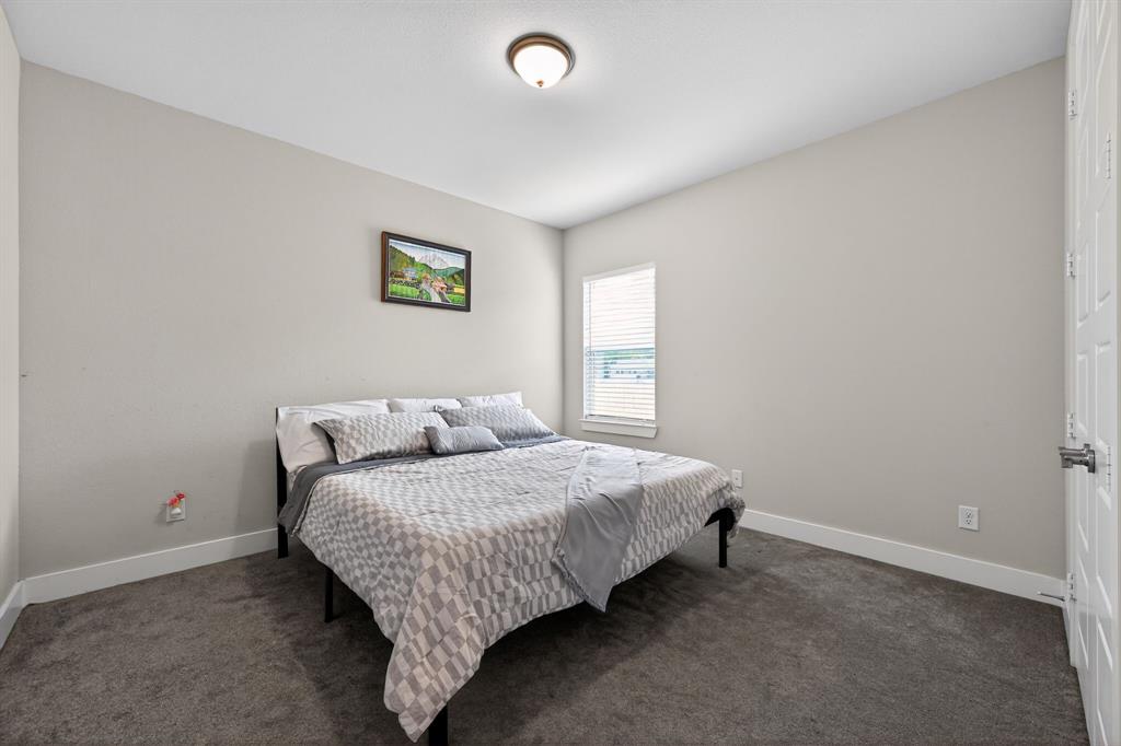411 West Harwood Road Euless, TX 76039 - Photo 21 of 29 This room features neutral-toned walls, a window with blinds, and carpeting