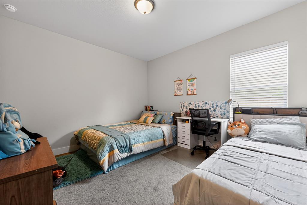 411 West Harwood Road Euless, TX 76039 - Photo 23 of 29 This room features light grey walls and grey carpet, with a window providing natural light