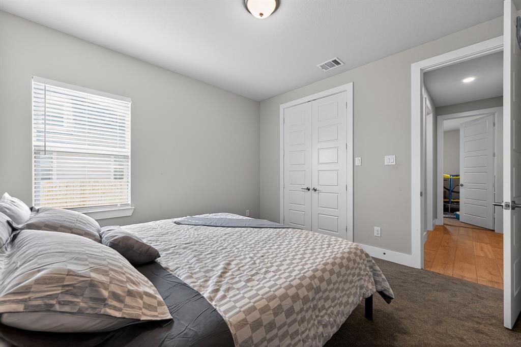411 West Harwood Road Euless, TX 76039 - Photo 24 of 29 This room features neutral-toned walls, a window with blinds, and white paneled closet doors