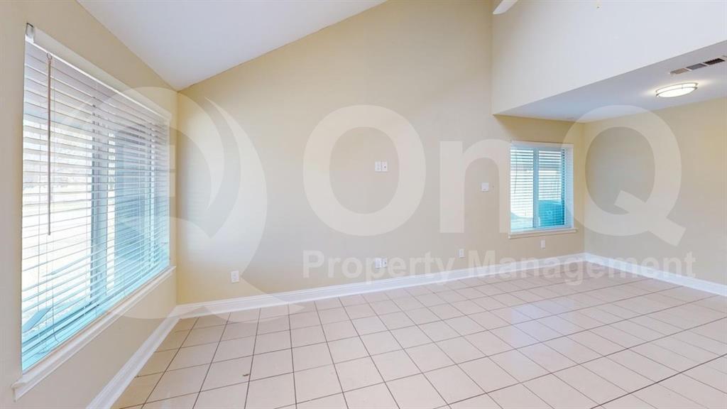 3005 Meandering Way Bedford, TX 76021 - Photo 7 of 24 Spacious room featuring vaulted ceilings, light-colored walls, and large windows with blinds