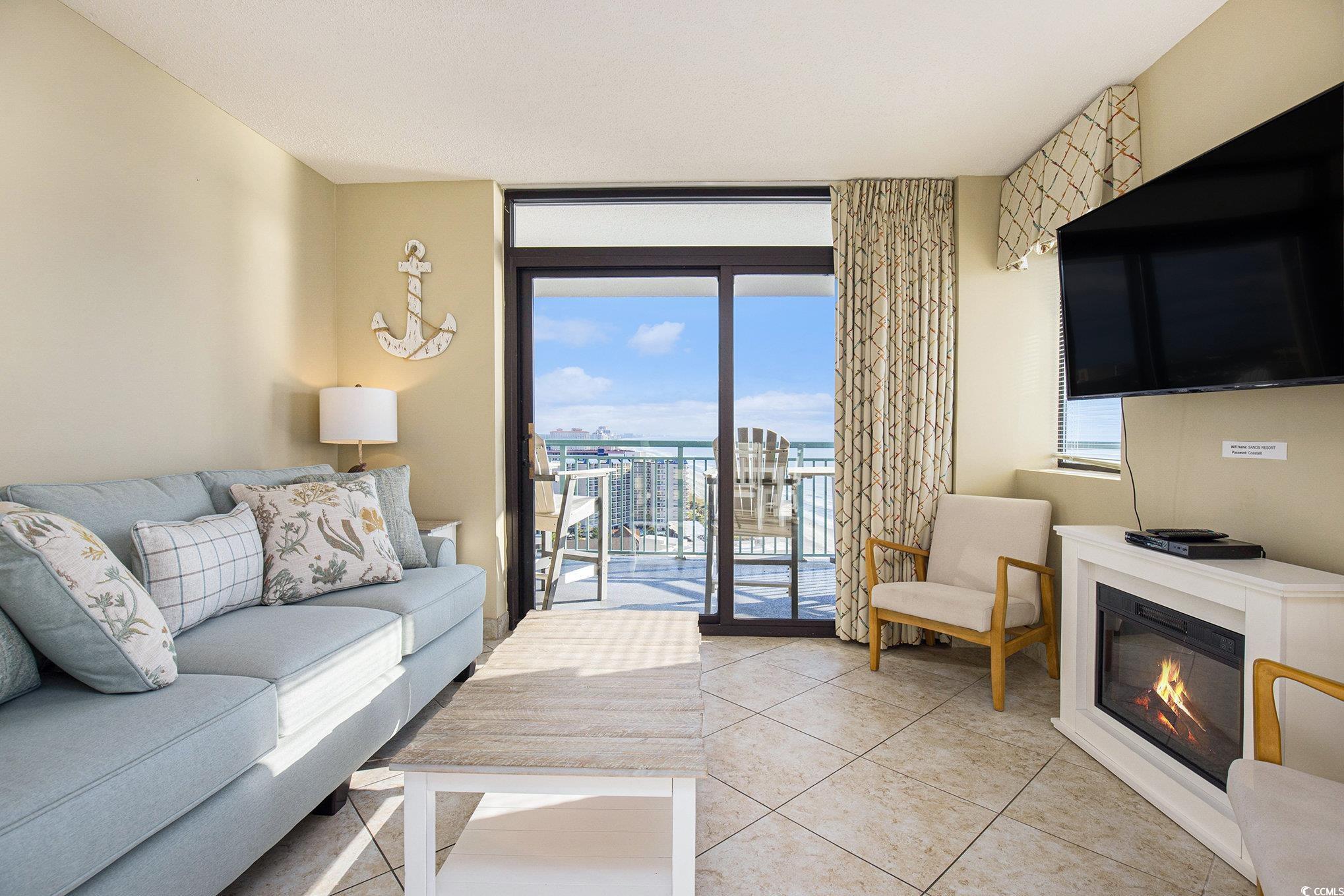 205 74th Avenue North, Unit 1810 Myrtle Beach, SC 29572 - Photo 21 of 37 Living area with floor to ceiling windows, light tile patterned flooring, and a glass covered fireplace