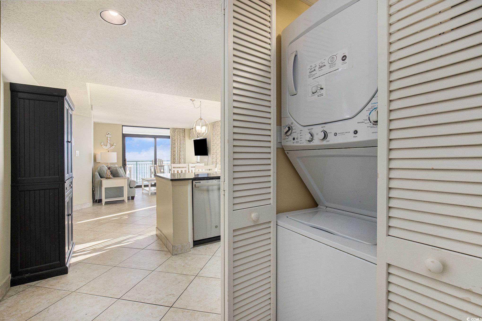 205 74th Avenue North, Unit 1810 Myrtle Beach, SC 29572 - Photo 25 of 37 Washroom with light tile patterned floors, stacked washer / dryer, and a textured ceiling