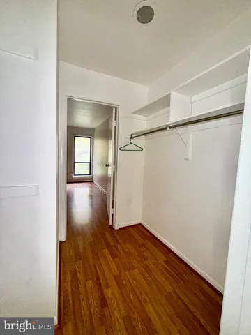 an empty room with wooden floor and closet