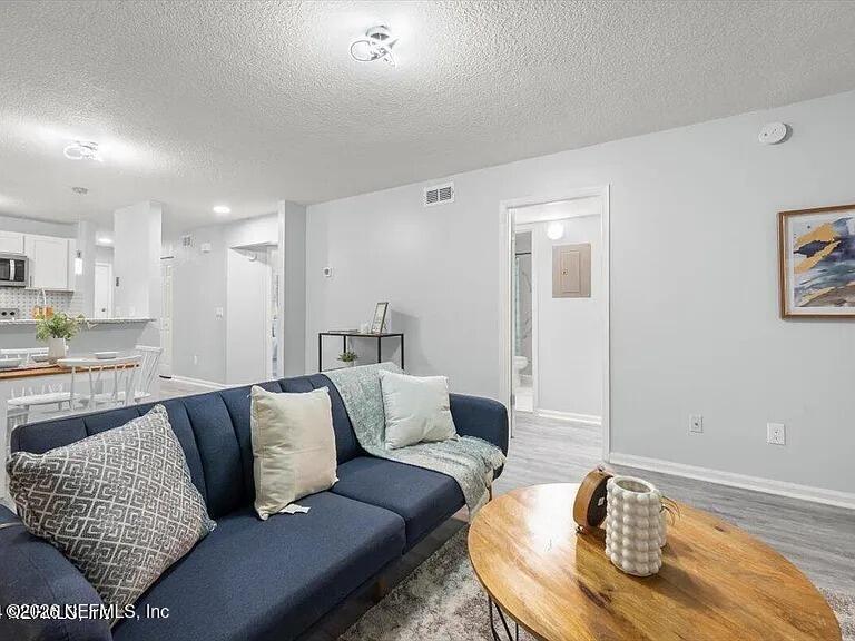3270 Ricky Drive, Unit 1501 Jacksonville, FL 32223 - Photo 4 of 22 a living room with furniture and a wooden floor