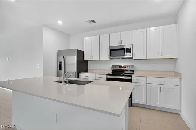 a kitchen with a sink and steel appliances