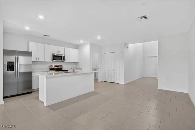a kitchen with white cabinets and stainless steel appliances