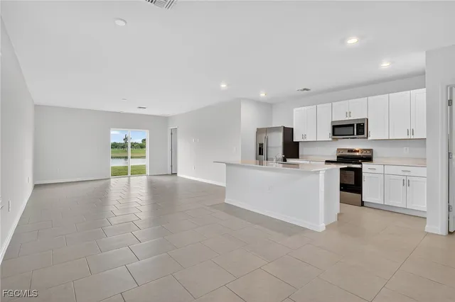a view of kitchen with cabinets microwave and stove top oven